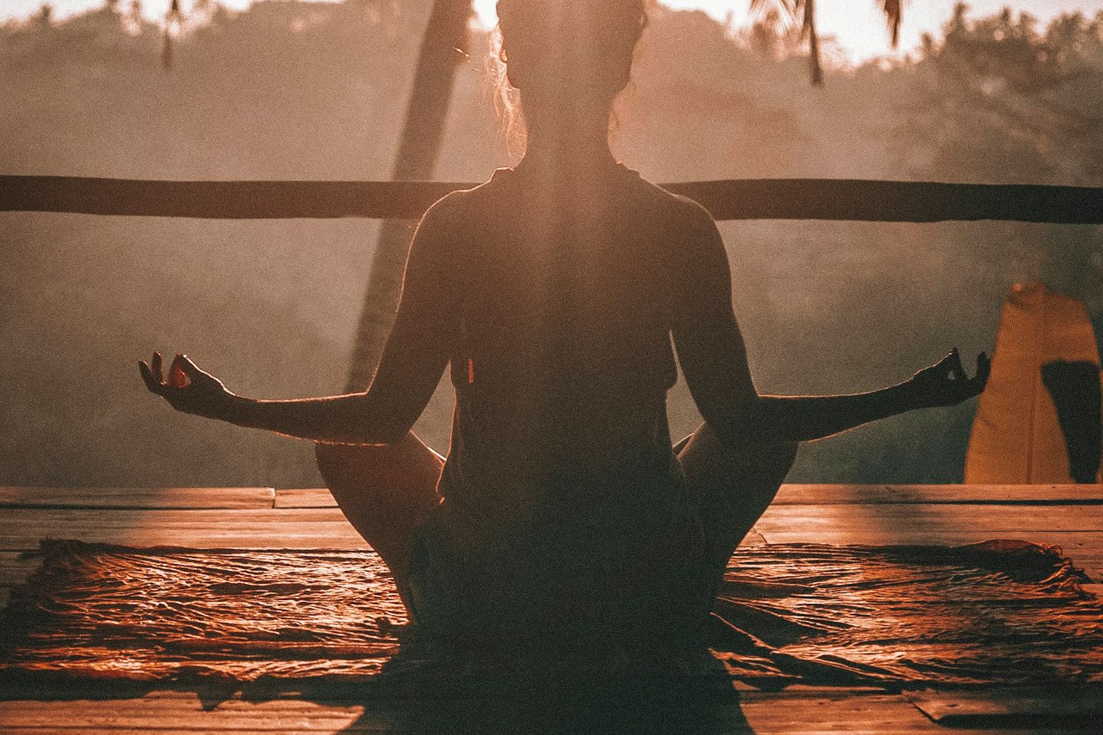 Person meditating outdoors in soft light